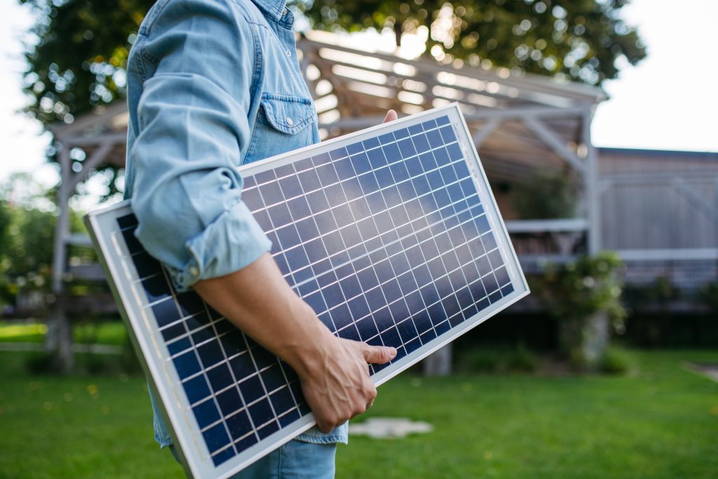 Muž nesúci solárny panel